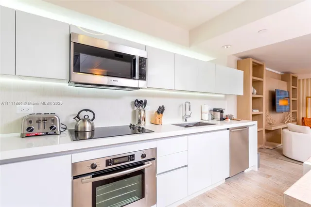 a kitchen with stainless steel appliances granite countertop a sink and a stove