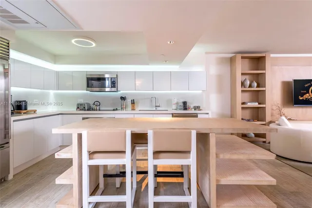 a kitchen with a dining table chairs refrigerator and cabinets