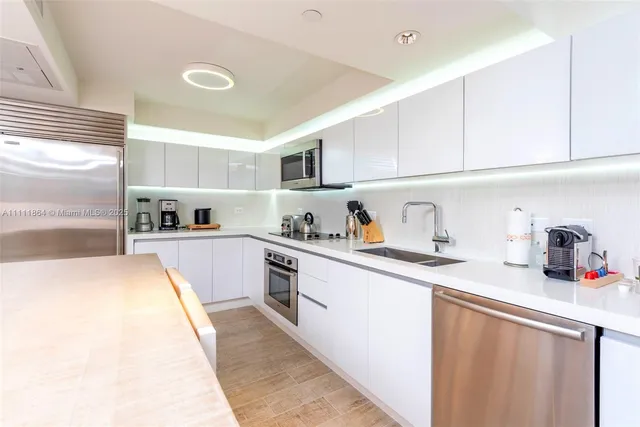 a kitchen with granite countertop a sink stainless steel appliances and cabinets