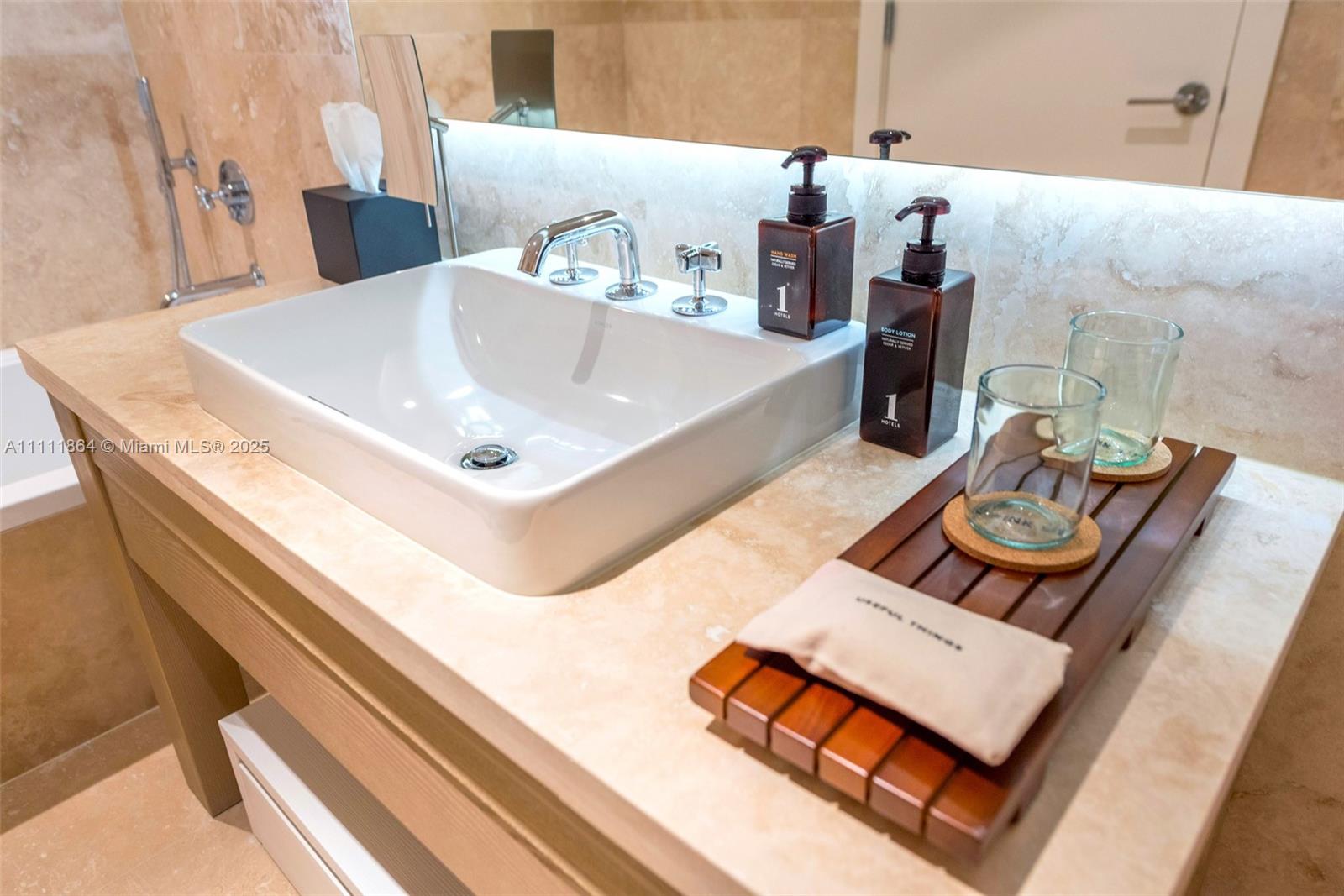 102 24th Street, Unit 906 Miami Beach, FL 33139 - Photo 10 of 15 a bathroom with a sink and a mirror