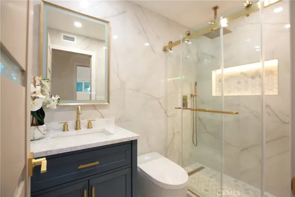 a bathroom with a sink a toilet and shower