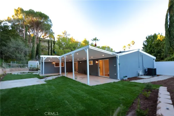 a view of a house with a yard and sitting area
