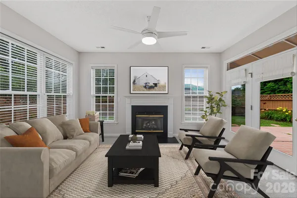a living room with furniture a fireplace and a large window