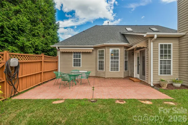 a backyard of a house with table and chairs