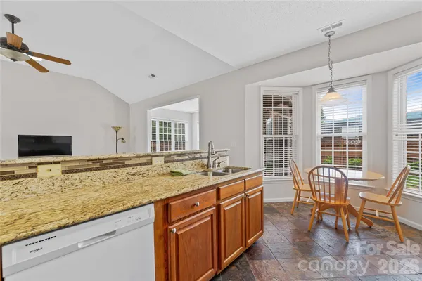 a view of a kitchen with a dining table chairs and a wooden floor