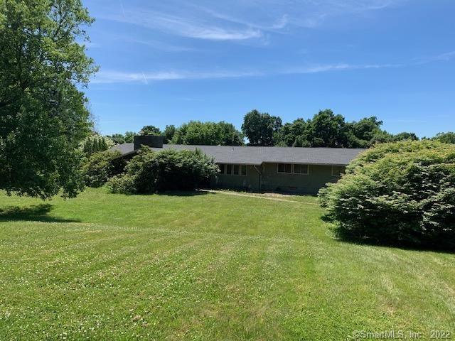 849 Litchfield Road Watertown, CT 06795 - Photo 1 of 1 a view of a garden with lawn chairs under an umbrella