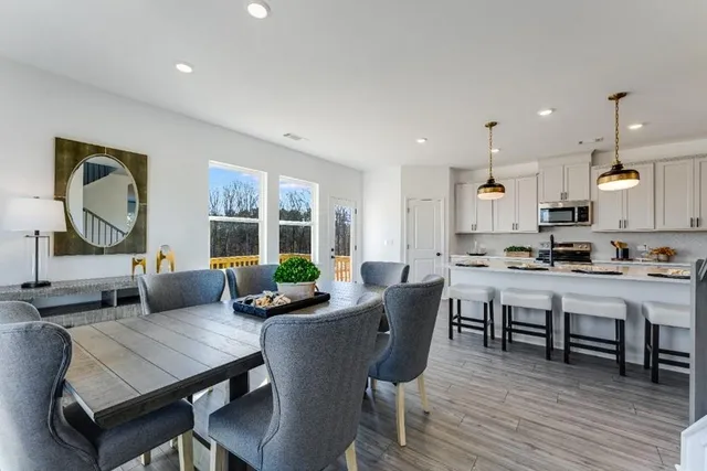 a kitchen with stainless steel appliances granite countertop a stove a sink dishwasher and a refrigerator with white cabinets