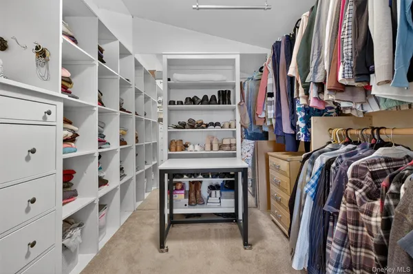 a view of walk in closet with clothes and shoes