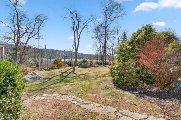 a view of swimming pool with lawn chairs and plants