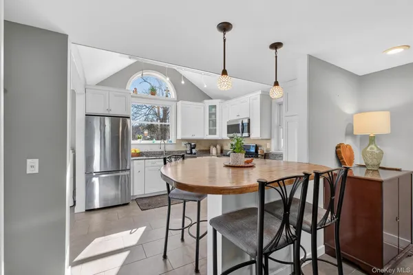 a view of a dining room and a kitchen with a table chairs