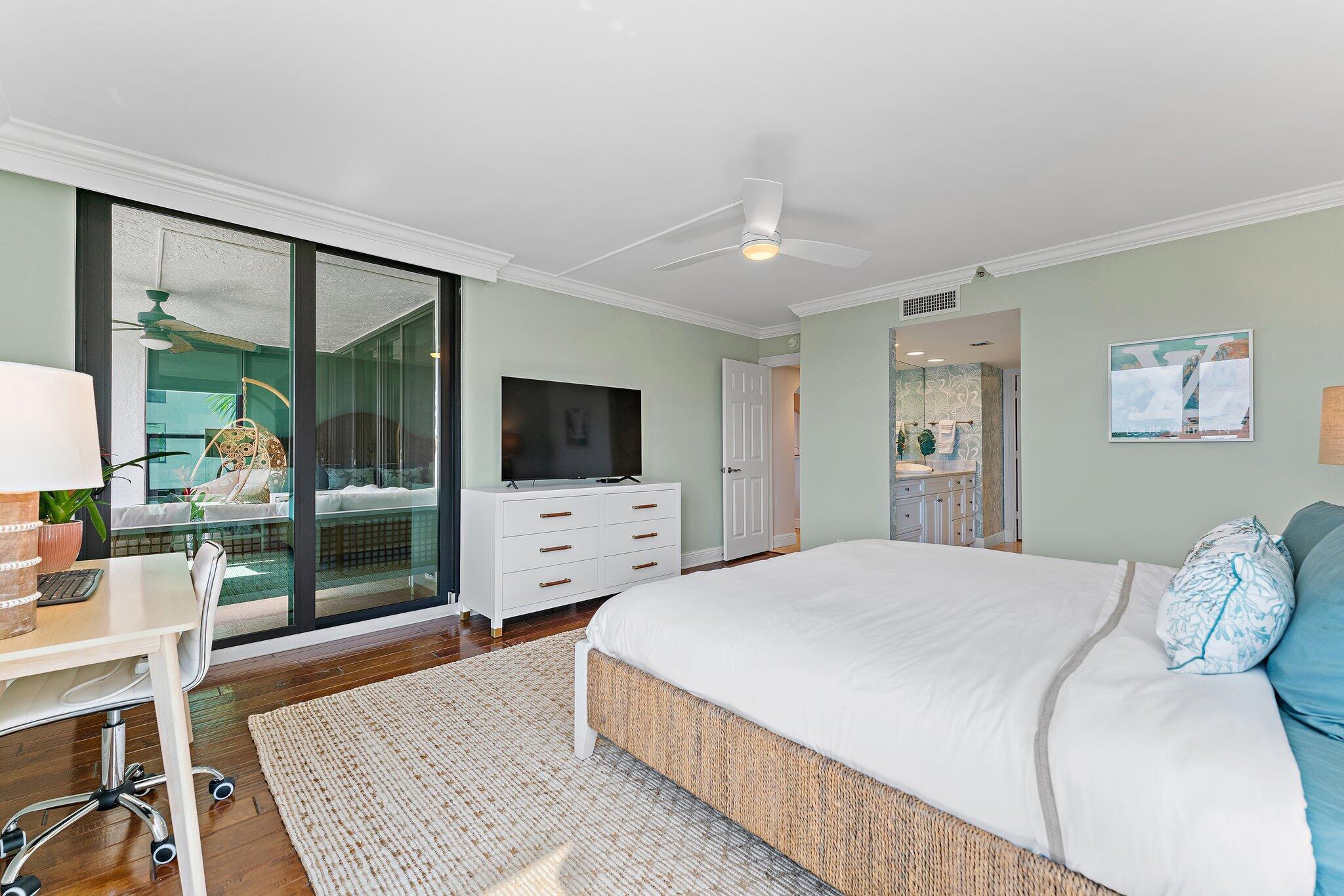 19670 South Beach Road, Unit B303 Jupiter, FL 33469 - Photo 44 of 104 a bedroom with a large bed and a flat screen tv
