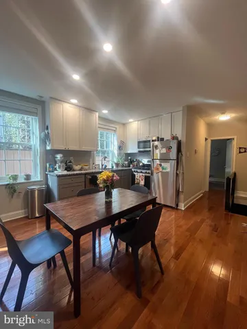 a kitchen with a dining table chairs and refrigerator