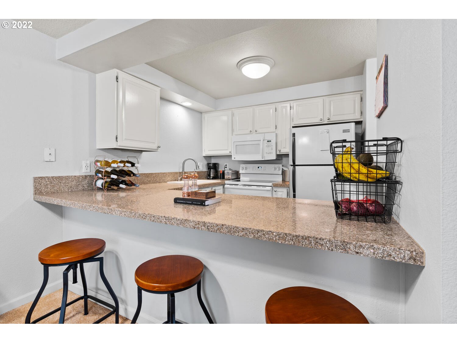 5503 Southwest Multnomah Boulevard Portland, OR 97219 - Photo 5 of 21 a kitchen with stainless steel appliances granite countertop a sink a stove and white cabinets