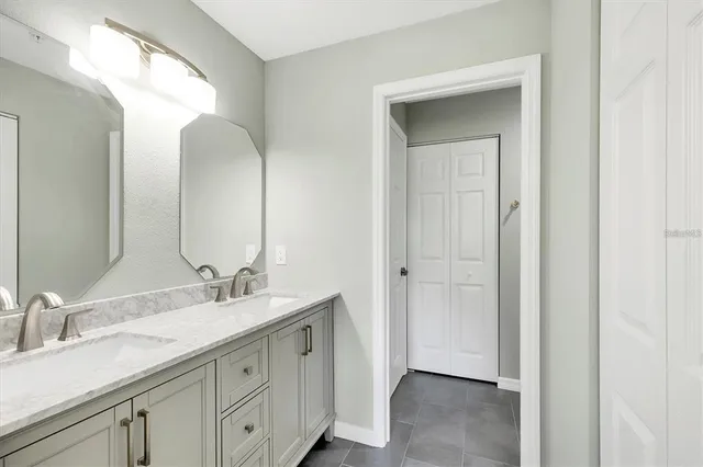 a en suite bathroom with a double vanity sink and a mirror