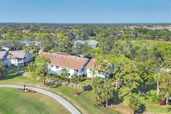 an aerial view of residential houses with outdoor space and trees