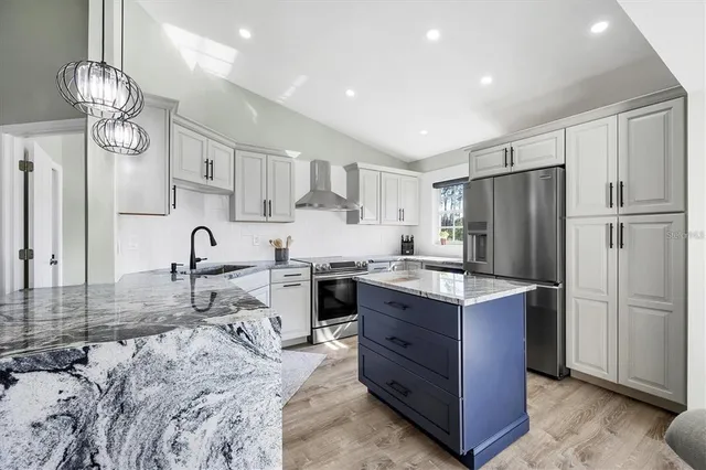 a kitchen with stainless steel appliances granite countertop a sink stove and refrigerator
