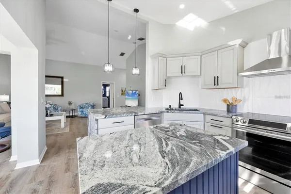 a kitchen with stainless steel appliances granite countertop a sink stove and refrigerator