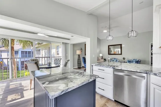 a kitchen with a stove a sink a dining table and chairs with wooden floor