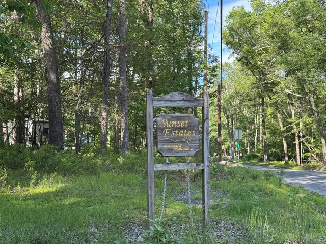 a sign that is sitting in front of a tree