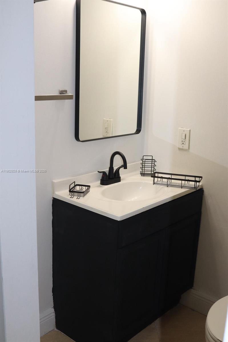 20022 Northwest 58th Court, Unit 1 Hialeah, FL 33015 - Photo 11 of 12 a bathroom with a sink and a mirror