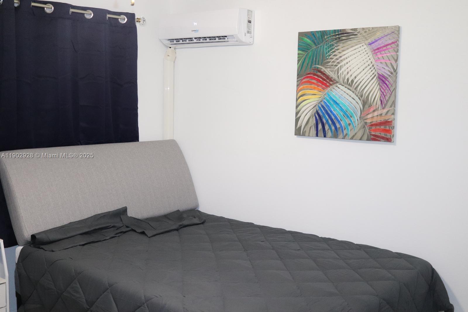 20022 Northwest 58th Court, Unit 1 Hialeah, FL 33015 - Photo 9 of 12 a bedroom with a bed and painting on the wall