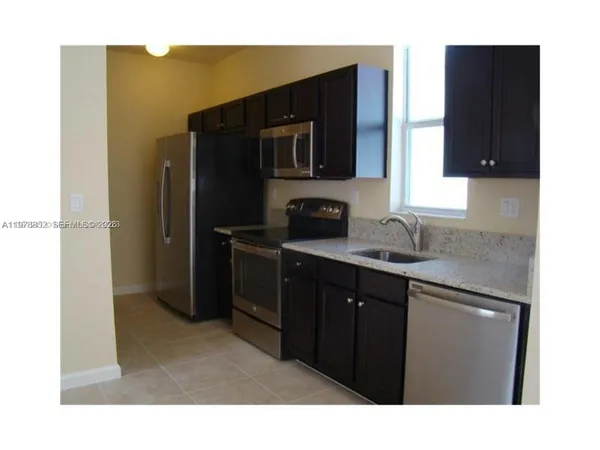 a kitchen with a refrigerator and a sink