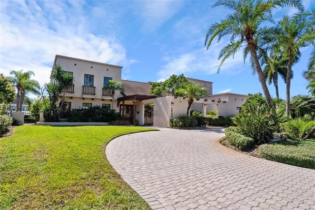 a view of a house with a yard and palm trees