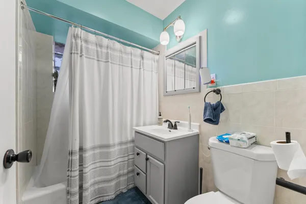 a bathroom with a sink a toilet and shower curtain