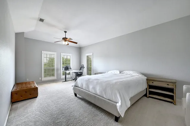 a spacious bedroom with a bed and a couch