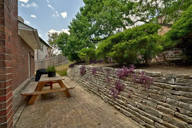 a view of a patio with table and chairs with wooden fence and plants