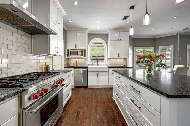 a kitchen with stainless steel appliances granite countertop a sink stove and cabinets