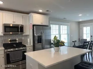 a kitchen with stainless steel appliances a microwave sink and refrigerator