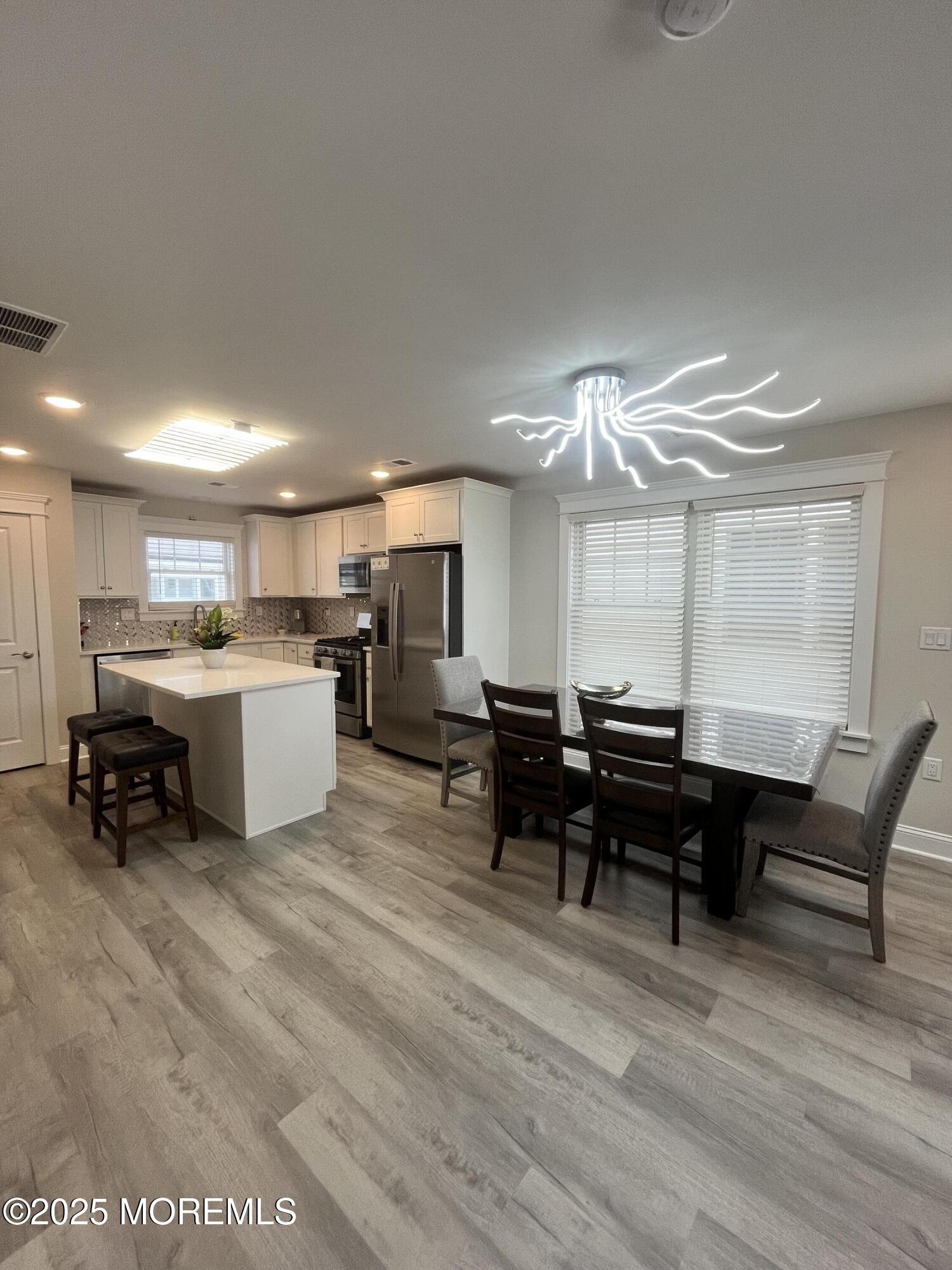 16 Elder Street, Unit 78 Mantoloking, NJ 08738 - Photo 4 of 26 a living room with furniture a dining table and chairs with wooden floor