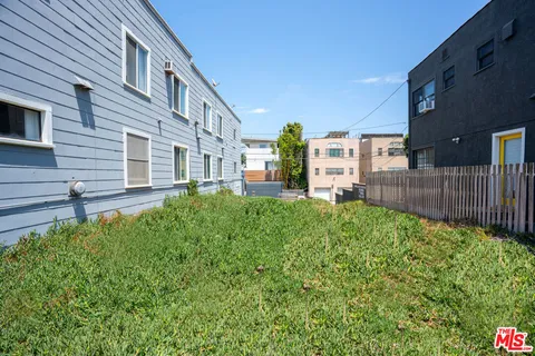 a view of a house with a small yard and wooden fence