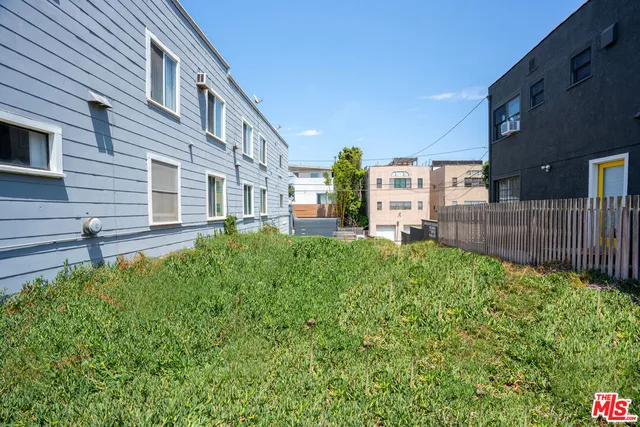 a view of a house with a small yard and wooden fence