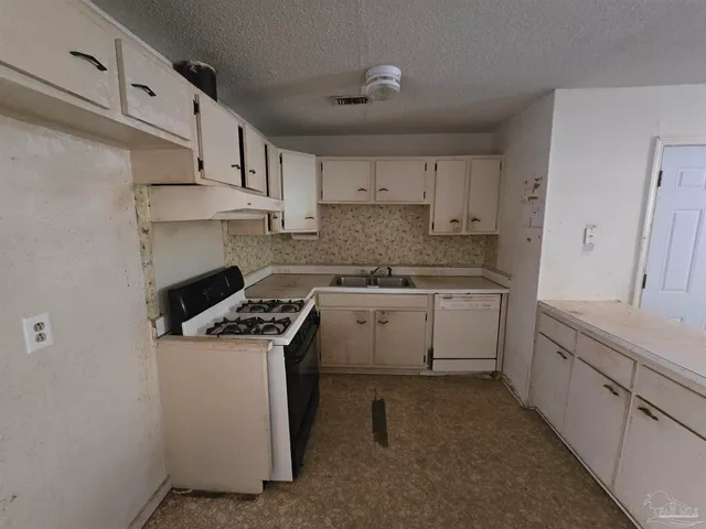 a kitchen with cabinets appliances a sink and a counter top space