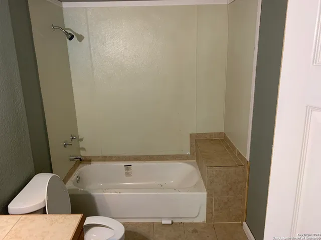 a bathroom with a tub shower and a sink