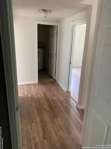 a view of a hallway with wooden floor