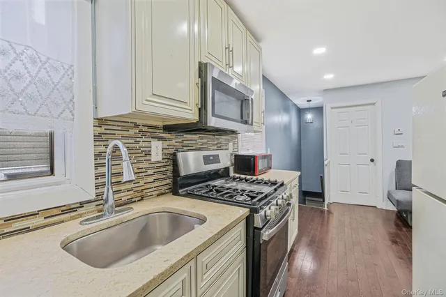 a kitchen with stainless steel appliances granite countertop a sink stove and refrigerator
