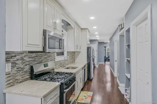a kitchen with stainless steel appliances granite countertop a stove a sink and a refrigerator