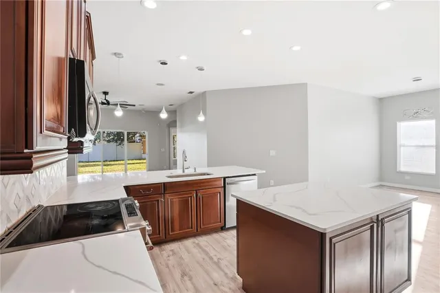 a kitchen with stainless steel appliances kitchen island wooden cabinets a chimney and a center island