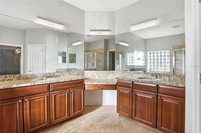 a bathroom with a granite countertop toilet a sink and a mirror