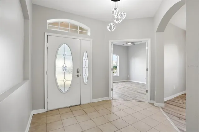 an empty room with wooden floor mirror and glass door