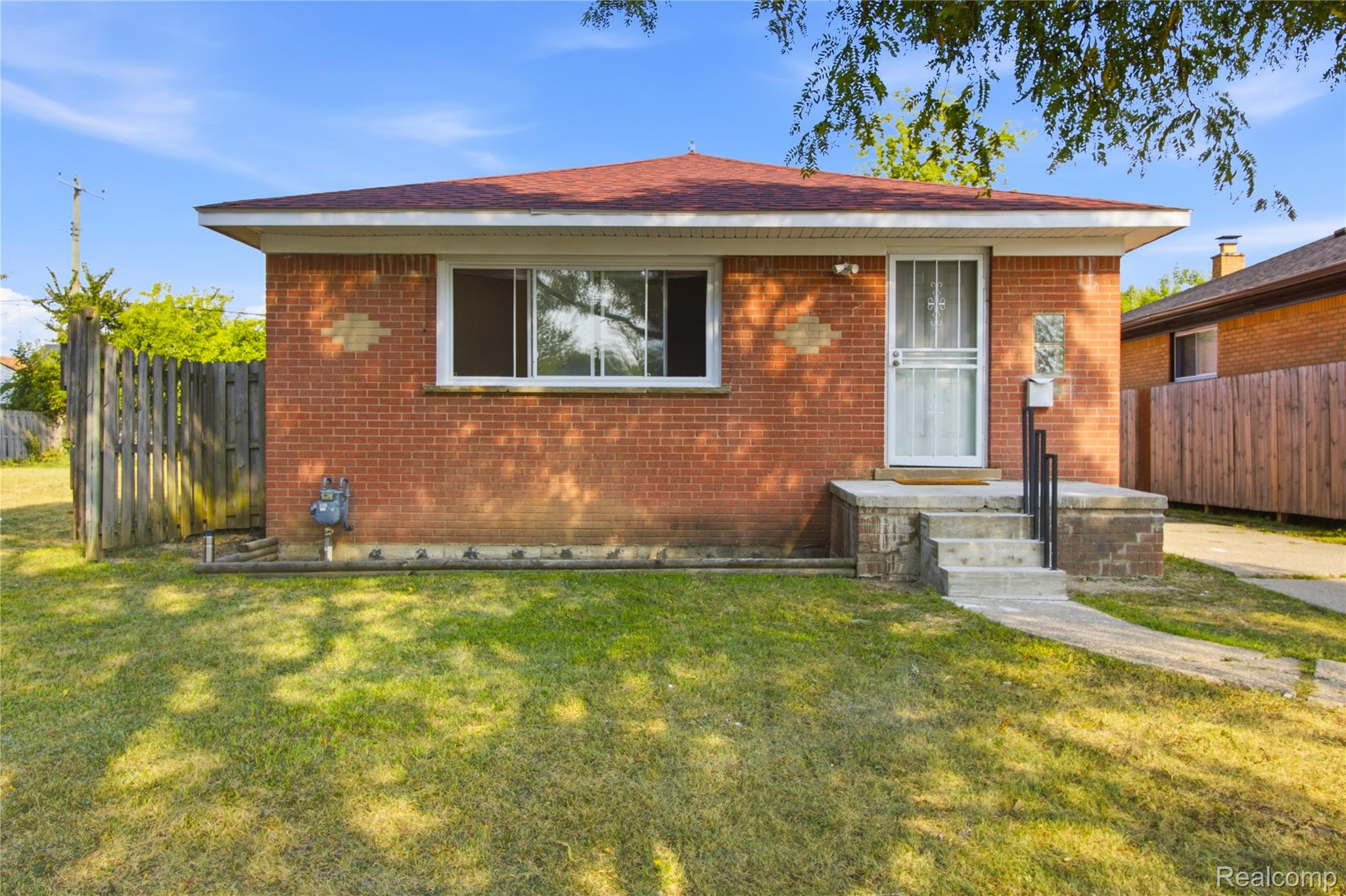Brick exterior with a red shingle roof, concrete front porch, and a white storm door