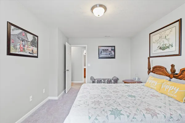 a bedroom with bed and painting on the wall