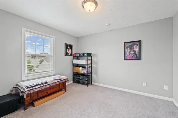 a view of a bedroom with furniture and window