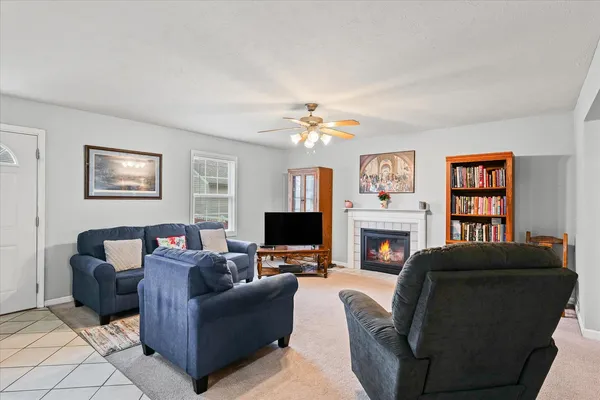 a living room with furniture a fireplace and a flat screen tv
