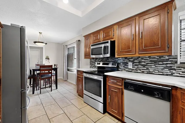 a kitchen with stainless steel appliances granite countertop a stove refrigerator and microwave