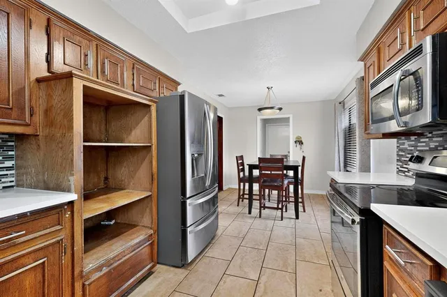 a kitchen with stainless steel appliances granite countertop a refrigerator and a stove top oven