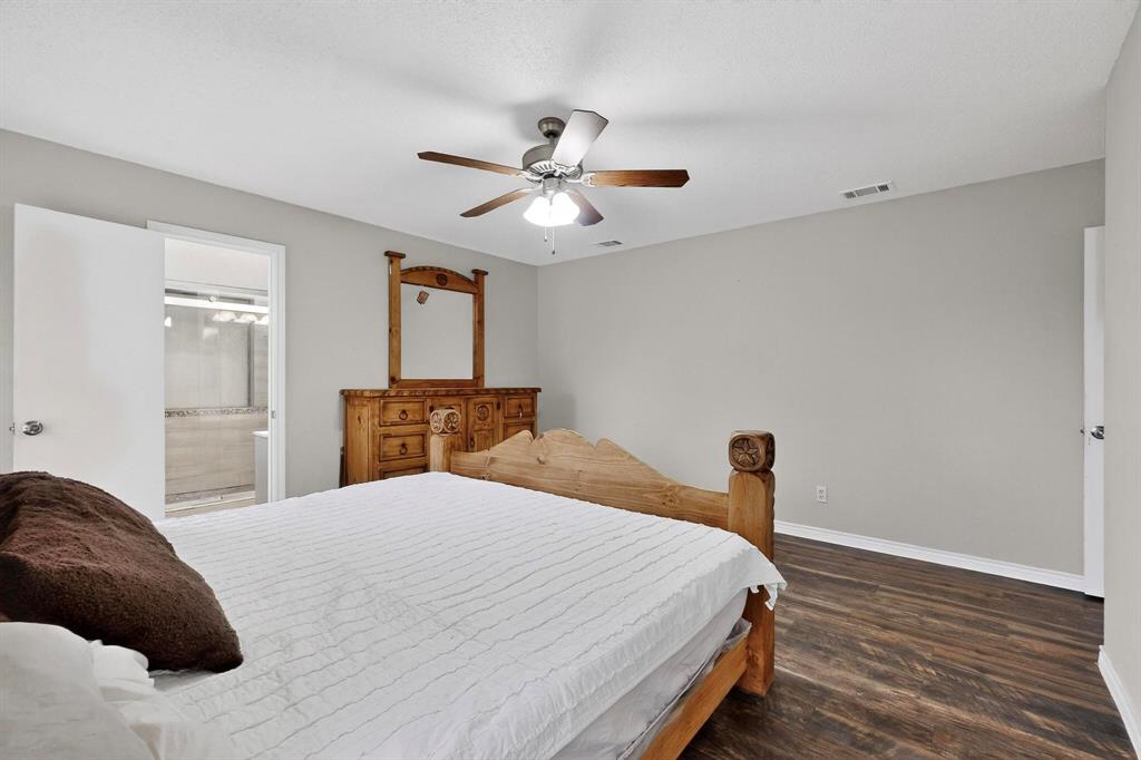 865 Harlan Road Combine, TX 75159 - Photo 17 of 38 a bedroom with a bed and a chandelier